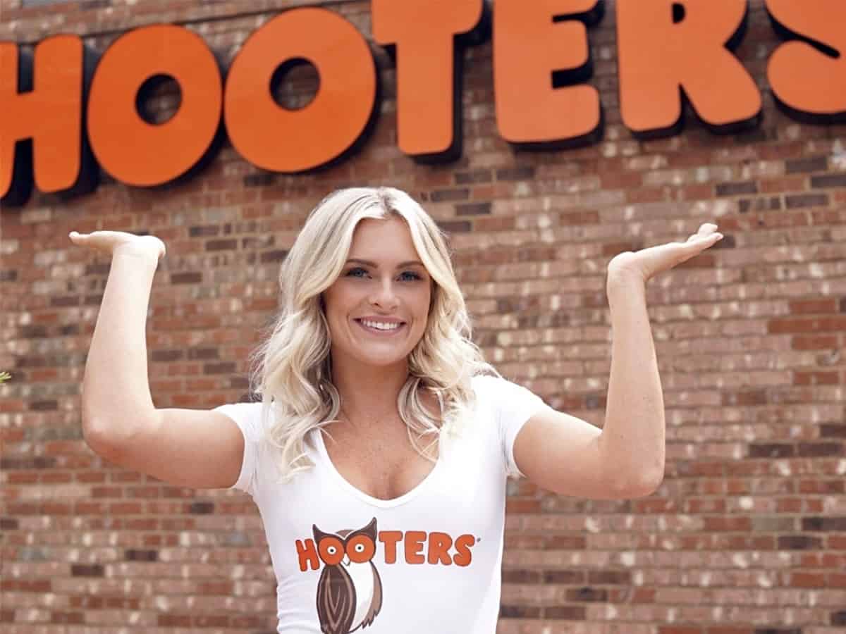 Beautiful Hooters Girl smiling in front of Hooters restaurant